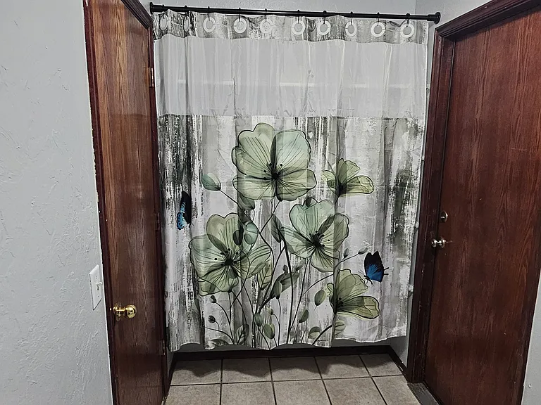 Pantry shelves with installed curtain rod and curtain