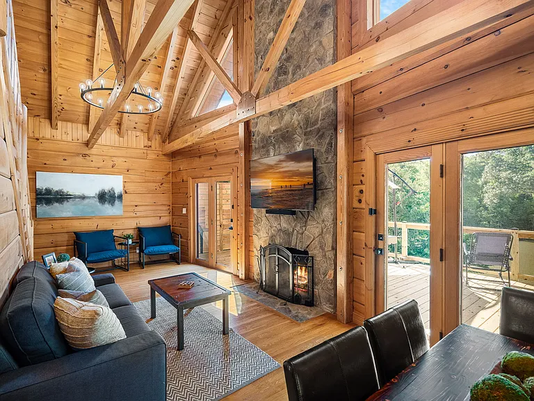 2 story family room with lake views. Glass doors flanking the stone fireplace lead to outdoor deck.
