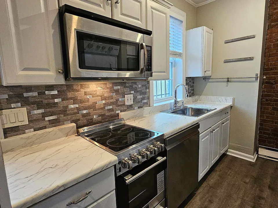 Renovated kitchen with modern, new stainless appliances (stove, d/w, microwave, fridge)