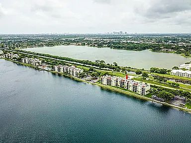 Aerial shot of Lake Emerald development, showcasing both lakes. Red arrow points to Building 117. Walking path extends the entire length of the lake inside the gated community.