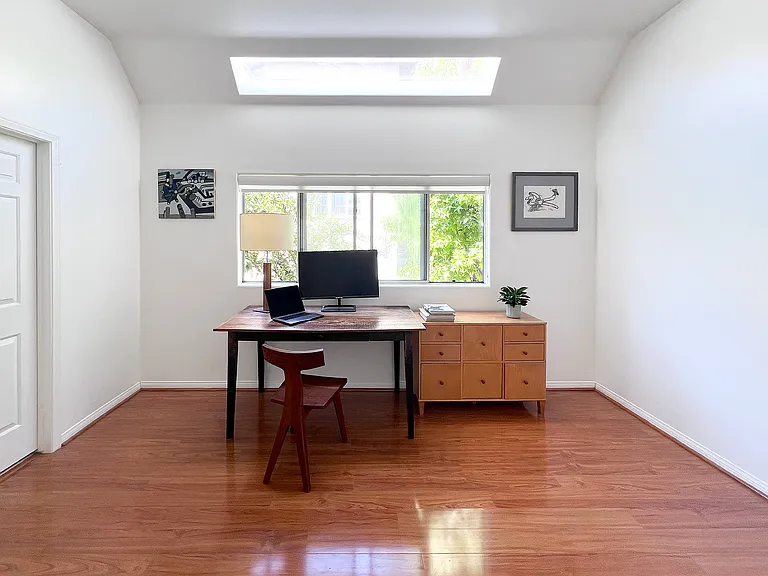 Modern second bedroom suite featuring an architectural high ceiling and a skylight that fills the space with natural light.