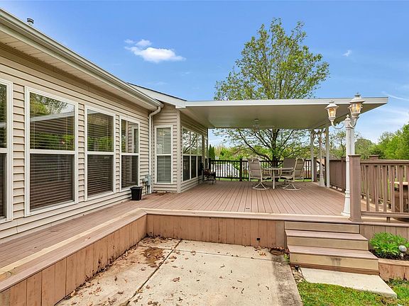Serene backyard with a covered deck and ceiling fan.