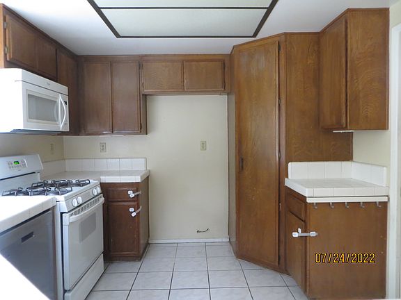downstairs: kitchen area with pantry and ample cabinetry, it looks out to the backyard.