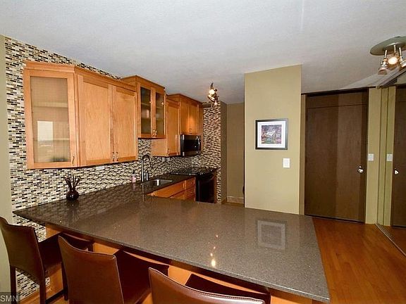 Stone counter, tile backsplash, new cabinets with bar seating/work area.