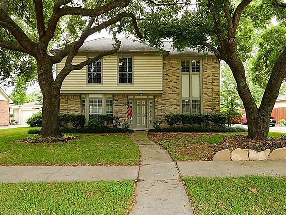Beautiful two-story brick home with large trees and mature landscaping has great curb appeal in the 