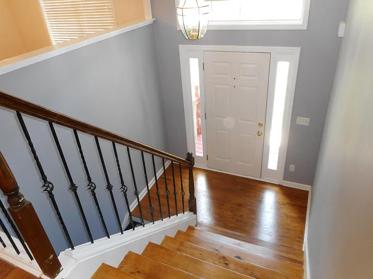 Front hallway polished hardwood stairs to the lower level ro