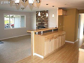 Living off kitchen with eat bar and wood burning fireplace
