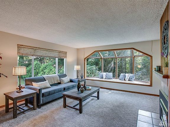 This spacious living room features two lovely windows. The bay window to the right overlooks the greenbelt and offers additional seating.
