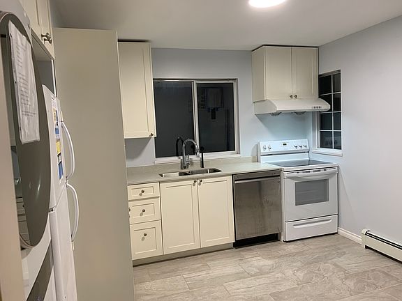 The kitchen was fully built in 2022, including the floor, with an electric stove and oven, dishwasher, large fridge, and an LG tower washer dryer.