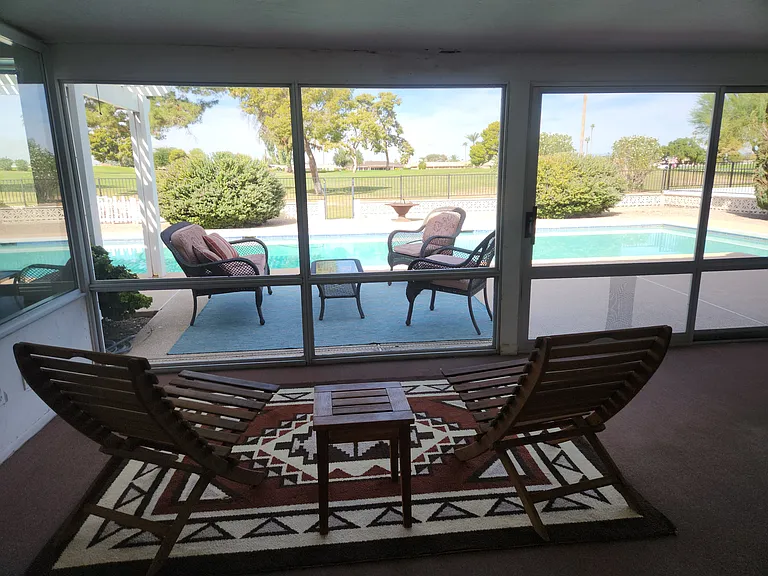 Screened porch with view of the pool and golf course