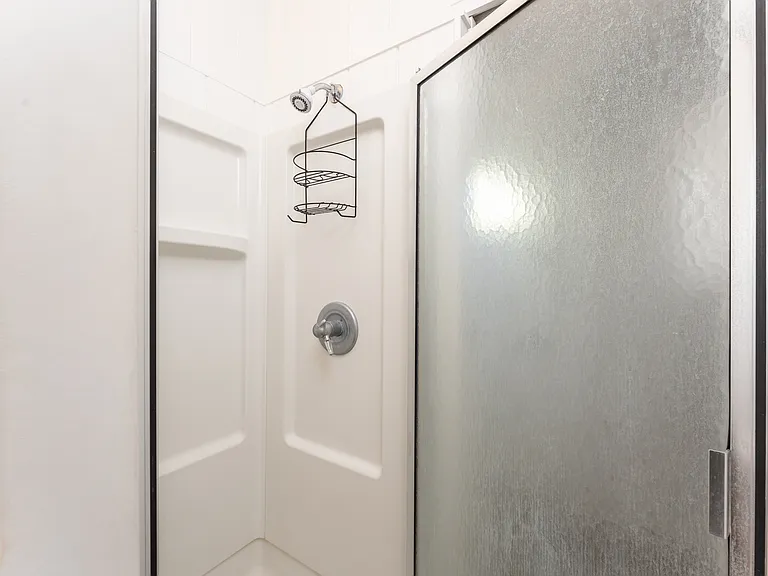 Private detached studio bathroom with walk-in shower and updated finishes, offering a clean and functional space for guests or extended living.
