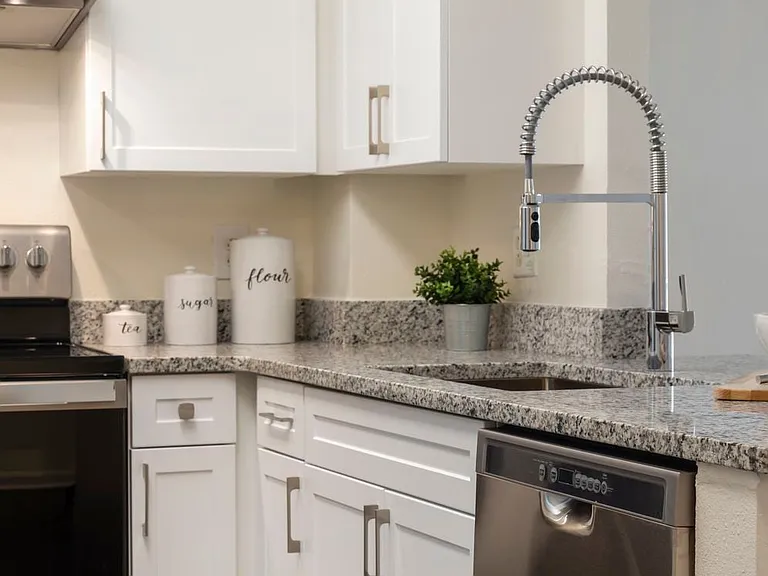 Renovated Package II kitchen with white cabinetry, quartz countertops, stainless steel appliances, and hard surface flooring