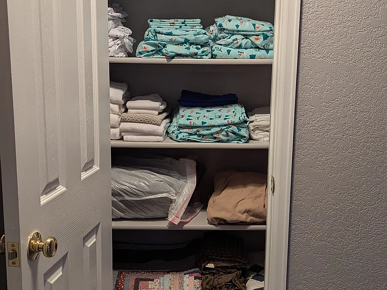 Linen cupboard at top of stairs, furnished down to the linens and towels