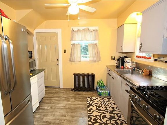 Bright & Airy Kitchen Has a Ceiling Fan, Painted Wooden Cabinetry, a Stainless Steel Counter top, Newer Contemporary Vinly Floor