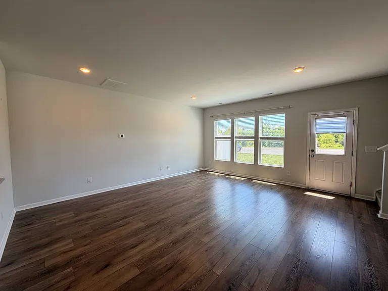Living room and back door (access to additional parking spots and dumpster)