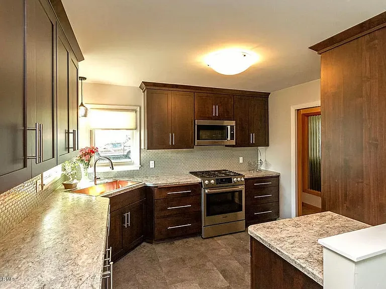 Upgraded kitchen with stainless steel appliances, beverage fridge, and five burner gas stove