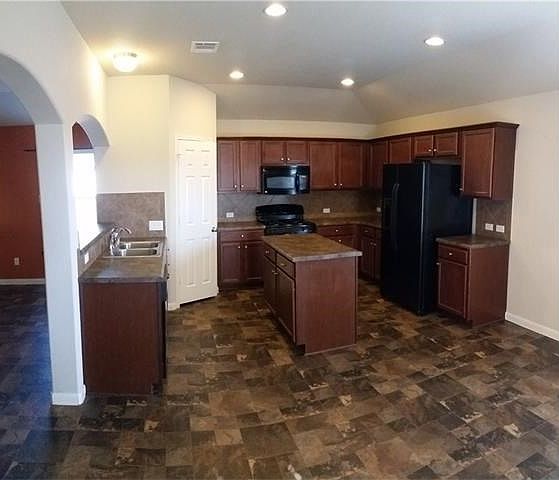 A chef's kitchen with extra cabinet space, fridge with ice a