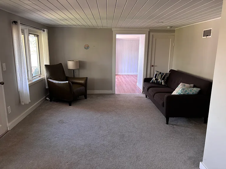 reverse view of livingroom area from bedroom area of second large room, view into kitchen room