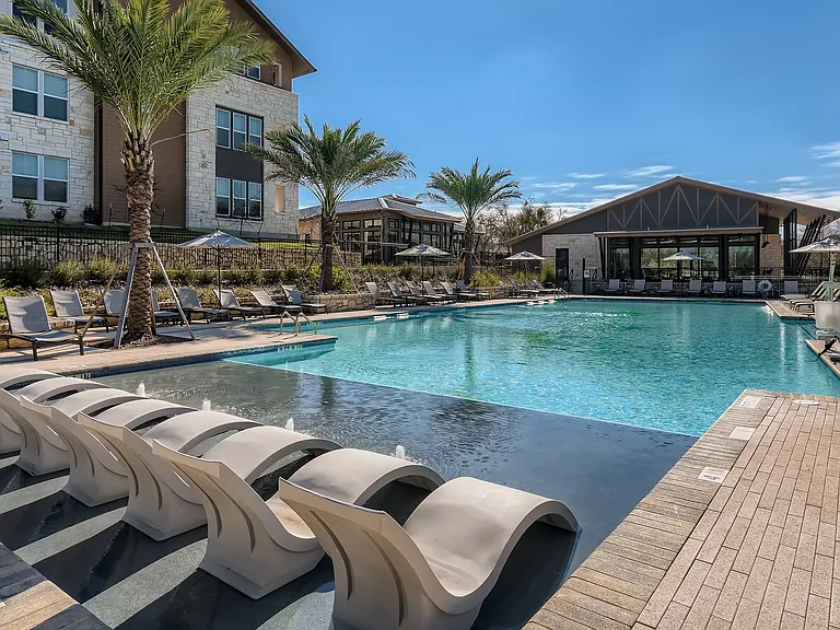 Resort-style swimming pool with in-water lounge chairs