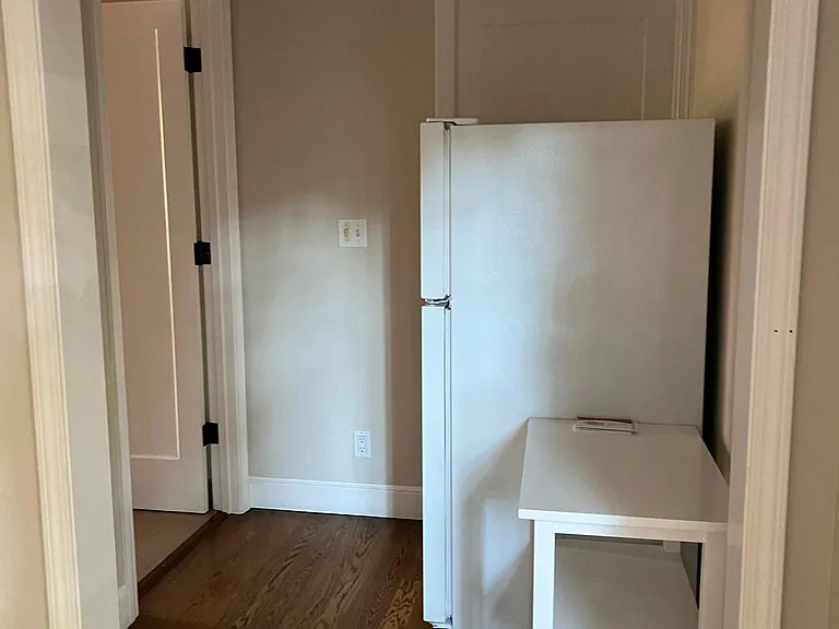 Central hall from kitchen with refrigerator and thermostat