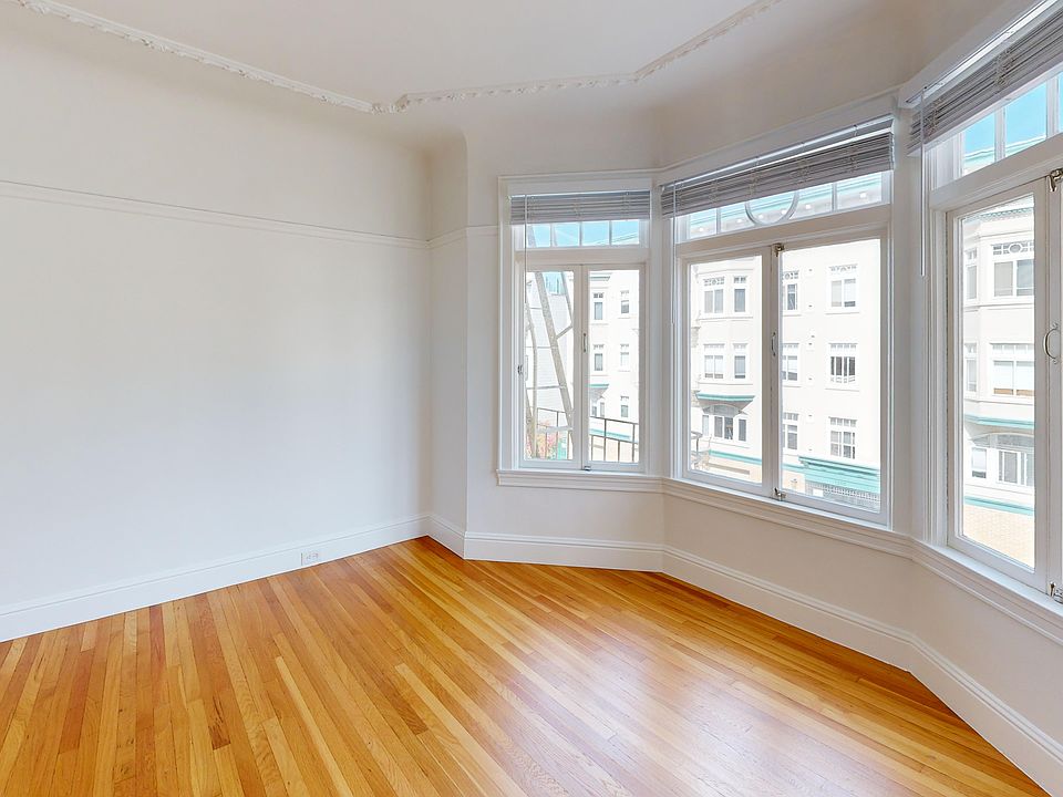 Spacious room with wood-like flooring and a large window offering natural light