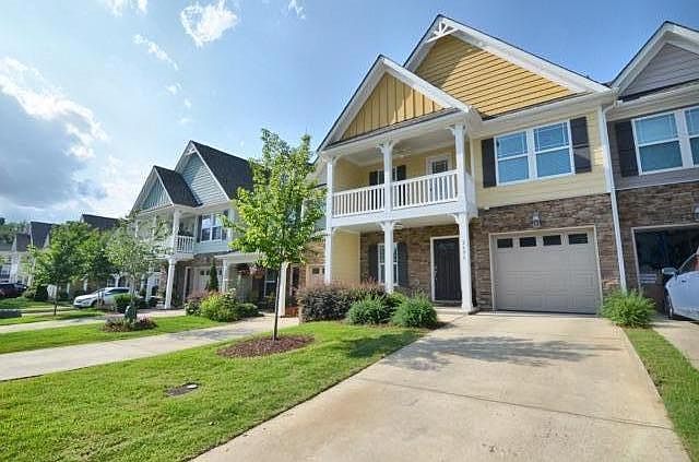 Front of townhome with one car garage, front stoop and 2nd story porch. No maintenance required (done by HOA; owner pays HOA dues)