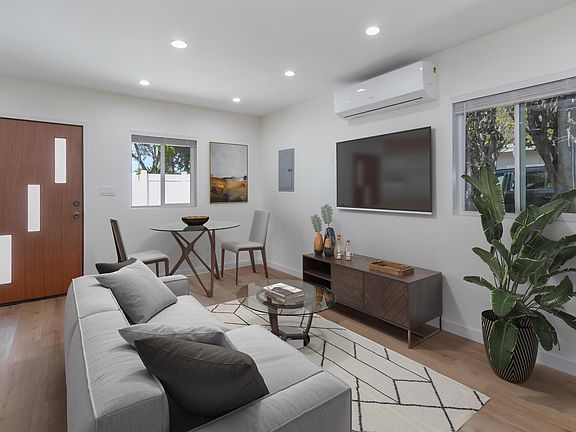 Living room area furniture & TV is staged.