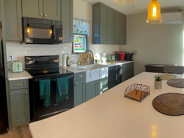 The kitchen is fully decorated with a farmhouse sink and art deco window. Amenities includes a full fridge, oven, toaster, microwave, farmhouse sink, dishwasher, and stacked washer and dryer. Guests will also have access to a single-serve Keurig machine w