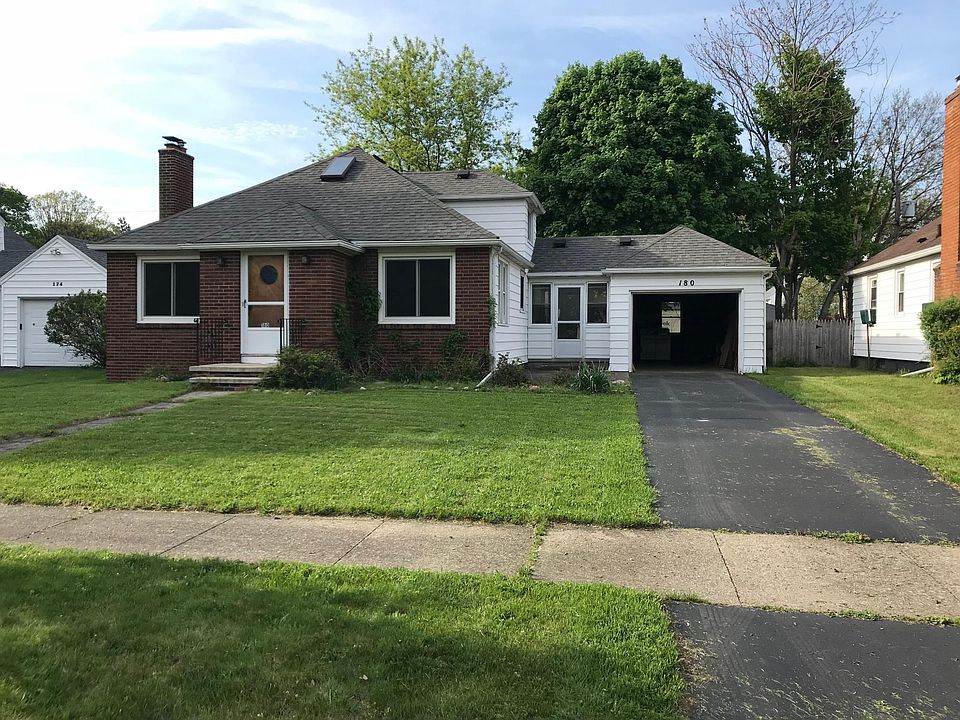 Front of house with garage door up.