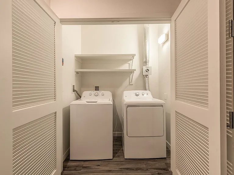Laundry room in Live and Work apartment at 1400 FIG Apartments, Elegant bathroom with walk-in shower in a Live and Work apartment at 1400 FIG Apartments in Los Angeles, California.