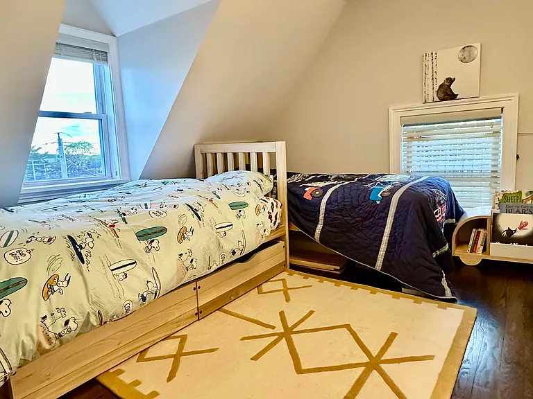 Bright third bedroom with hardwood floors, charming ceiling lines, and flexible use.