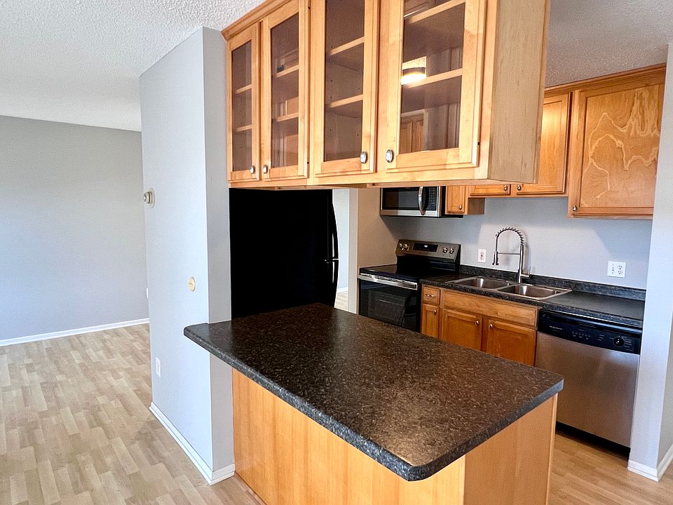 Breakfast bar with granite look counter, maple cabs with pass-through glass doors. New paint. Entire unit will be this color.