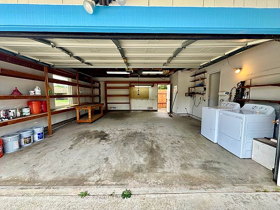 2 car garage with storage shelving, washer/dryer and irrigation timer