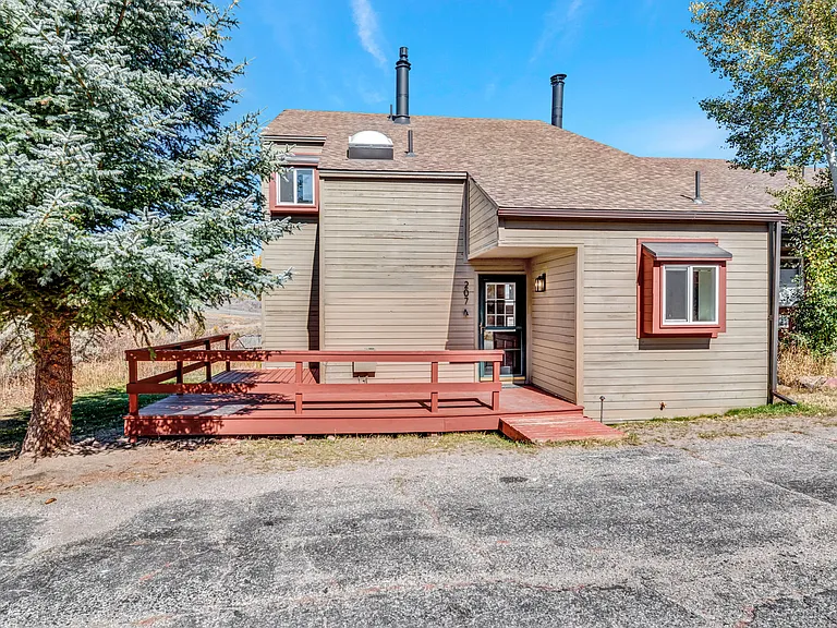#207 is an end unit, with a wrap around front deck, small back storage shed, and parking area out front