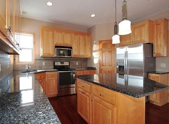 Center Island kitchen with cherry wood floors, maple cabinets, granite counters, tile backsplash, Brand New Stainless Steel Refrigerator and Range, pendant lights, walk-in pantry, 9' ceilings