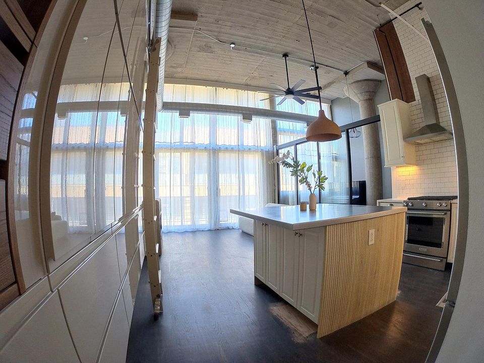 Kitchen with custom pantry + Island and rolling ladder. Kitchenaid range/oven Rejuvenation pendant. ( Floors will be finished 03/22/22)