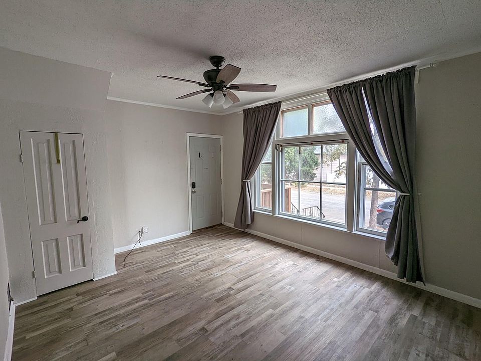 Main entry door and living room. Spacious window facing Churchill Street for natural light. Ceiling fan for air flow. Closet for coats and shoes.