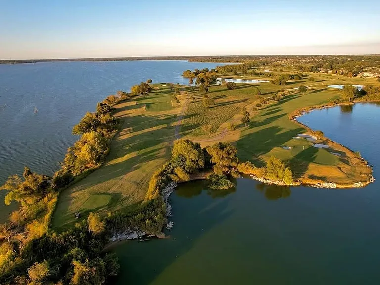 Expansive golf course property featuring waterfront access and mature trees