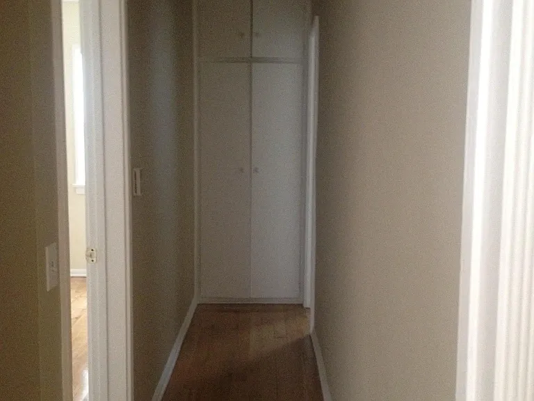 Hall way with entrance to bedroom on left and bathroom at end of hallway
