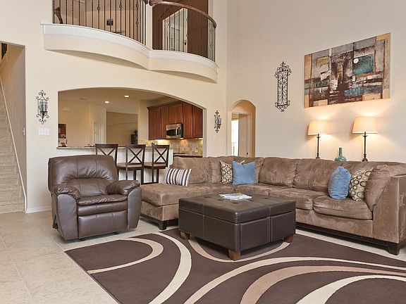 The oversized den is open to the kitchen. Featuring soaring two-story ceilings, this is a perfect place to entertain or hang out with your family! Note the Romeo & Juliet balcony upstairs overlooking the den.