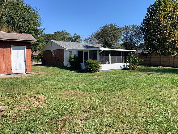 back of house with screen porch and with the shed on the left.