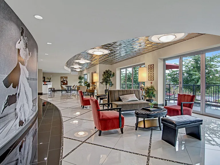 A large, shared space with chairs, couches, and a patio for resident use