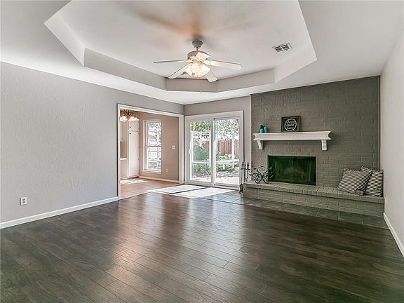Living area with tray ceiling, wood/gas fireplace, new patio door