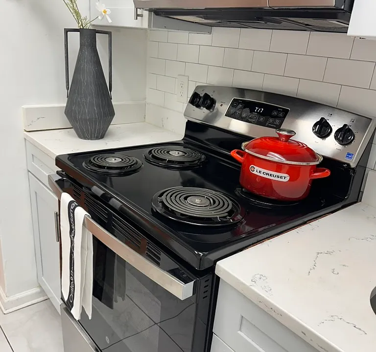 REFURBISHED KITCHEN _ Bright and inviting black-and-white kitchen with stainless-steel appliances, a new stove, tiled finishes, and new double-pane windows.