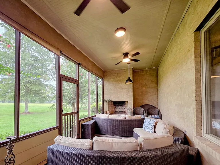 Screen porch with views of grassy yard. Fireplace in the screen porch