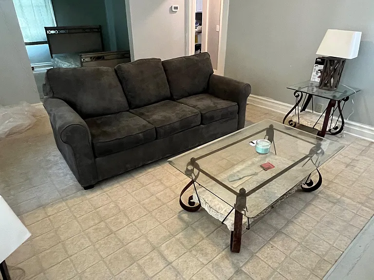 Living area with tiled floors, comfortable seating, and an open archway connecting to adjacent rooms for easy flow.