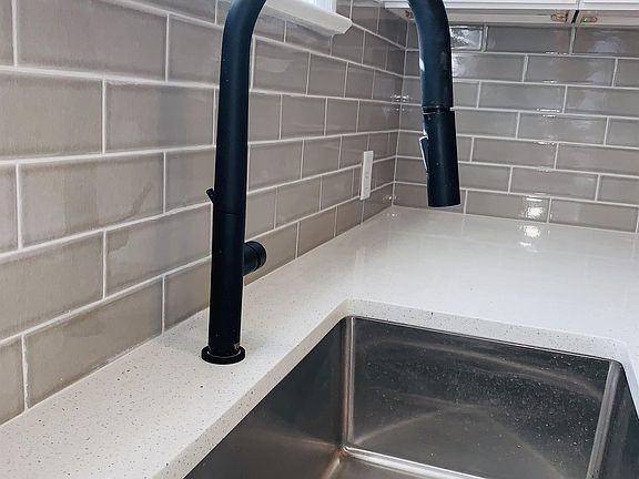 Kitchen has a high-end telescoping faucet and deep stainless steel sink