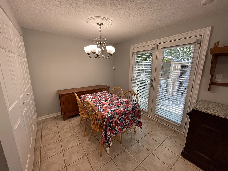 Dining room with french door access to deck, buffet, and chandelier with ceiling medallion