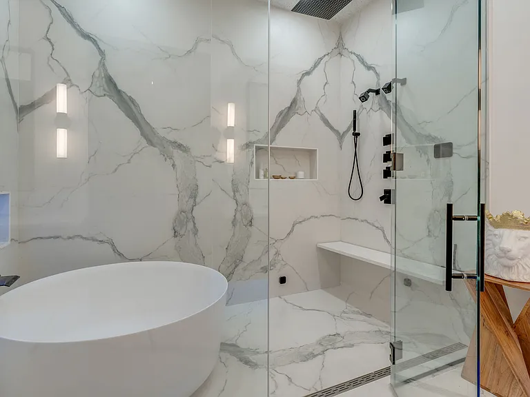 first floor primary bathroom, custom built, expansive shower room with round soaking tub, bench, steam controls, dual shower heads, wand, and rain shower.