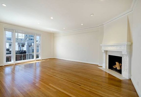 Unit #402 living room with wood burning fireplace, stunning hardwood floors and can lighting throughout! This fireplace mantel is gorgeous!